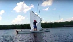 Viola 14 sailing canoe hoisting sail on the water super stable stability